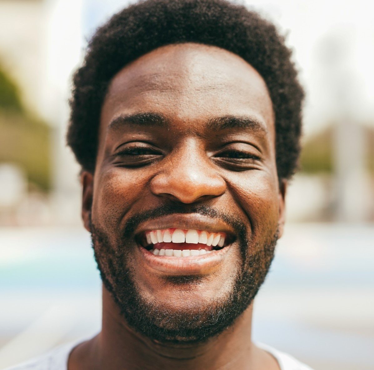 Testimonials happy african man smiling at camera inside ba 1.jpg
